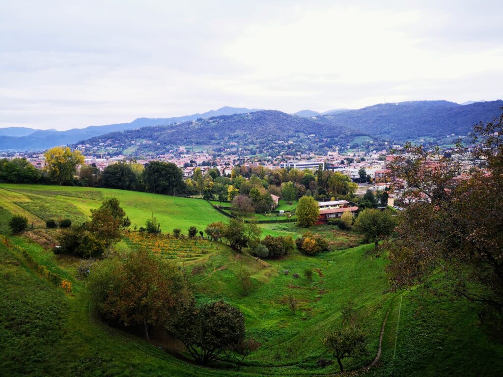 Wzgórza Bergamo - liczne domki i góry w tle
