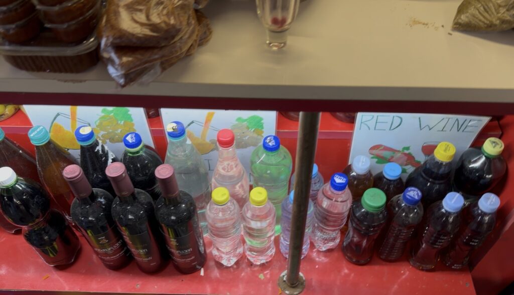 Gruzińskie wino czacza i inne alkohole sprzedawane w plastikowych butelkach na targu w Kutaisi